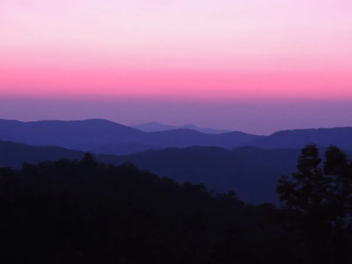 A breathtaking view of expansive mountain ranges beneath a colorful sky, capturing the grandeur and tranquility of the High Country. The scene invites thoughts of exploration, hiking, and family adventures in nature.